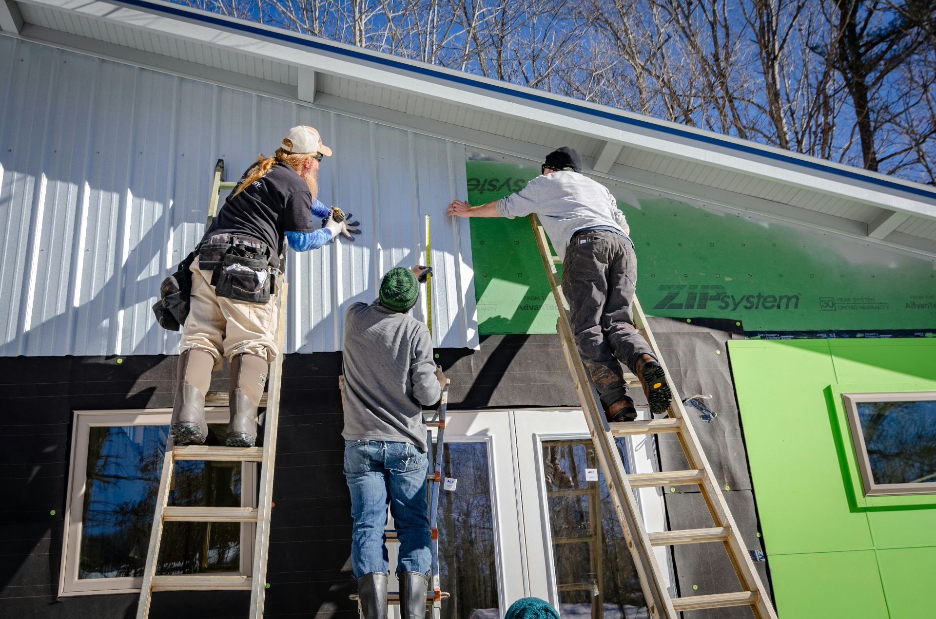 Crew installing siding on a new build