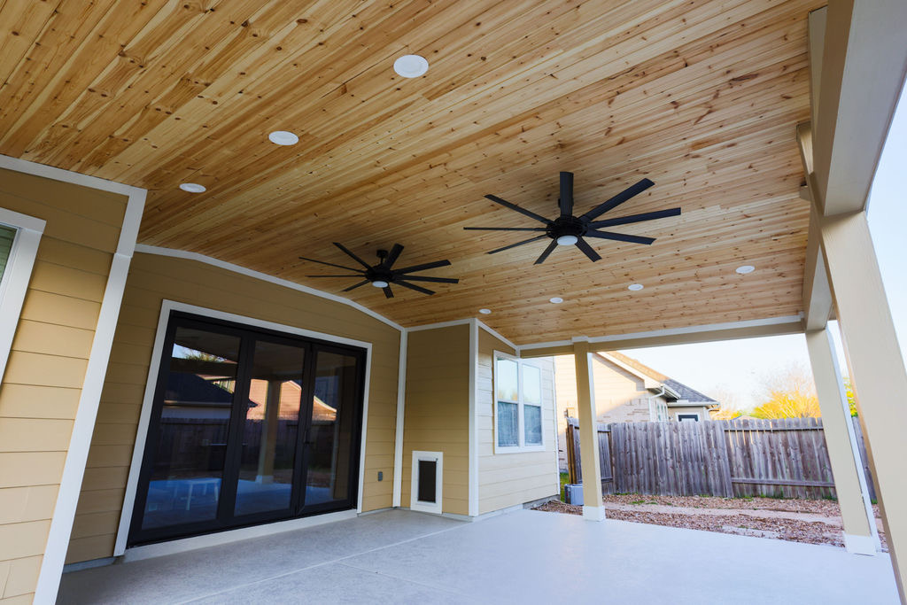 Wood-clad covered patio ceiling with fans installed by EC Builders