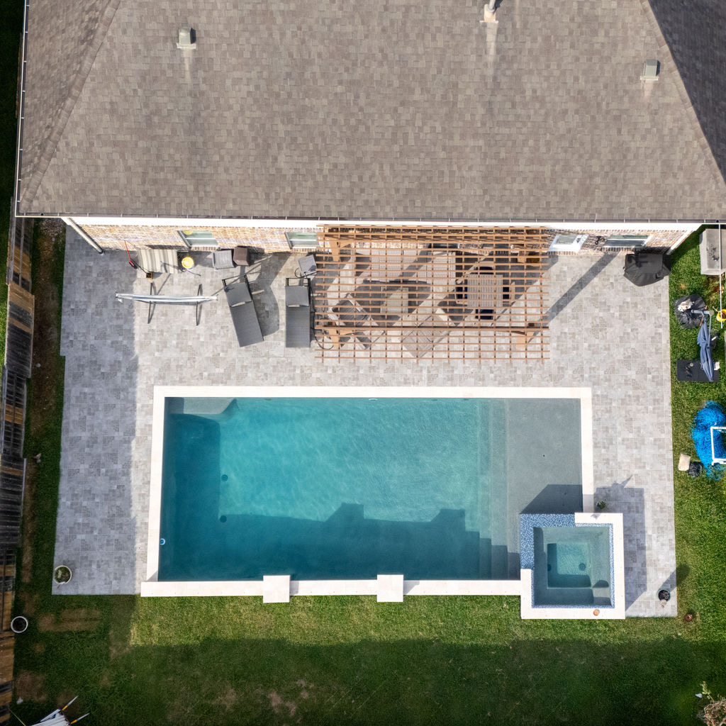 Aerial view of backyard outdoor living project with pool and patio by EC Builders
