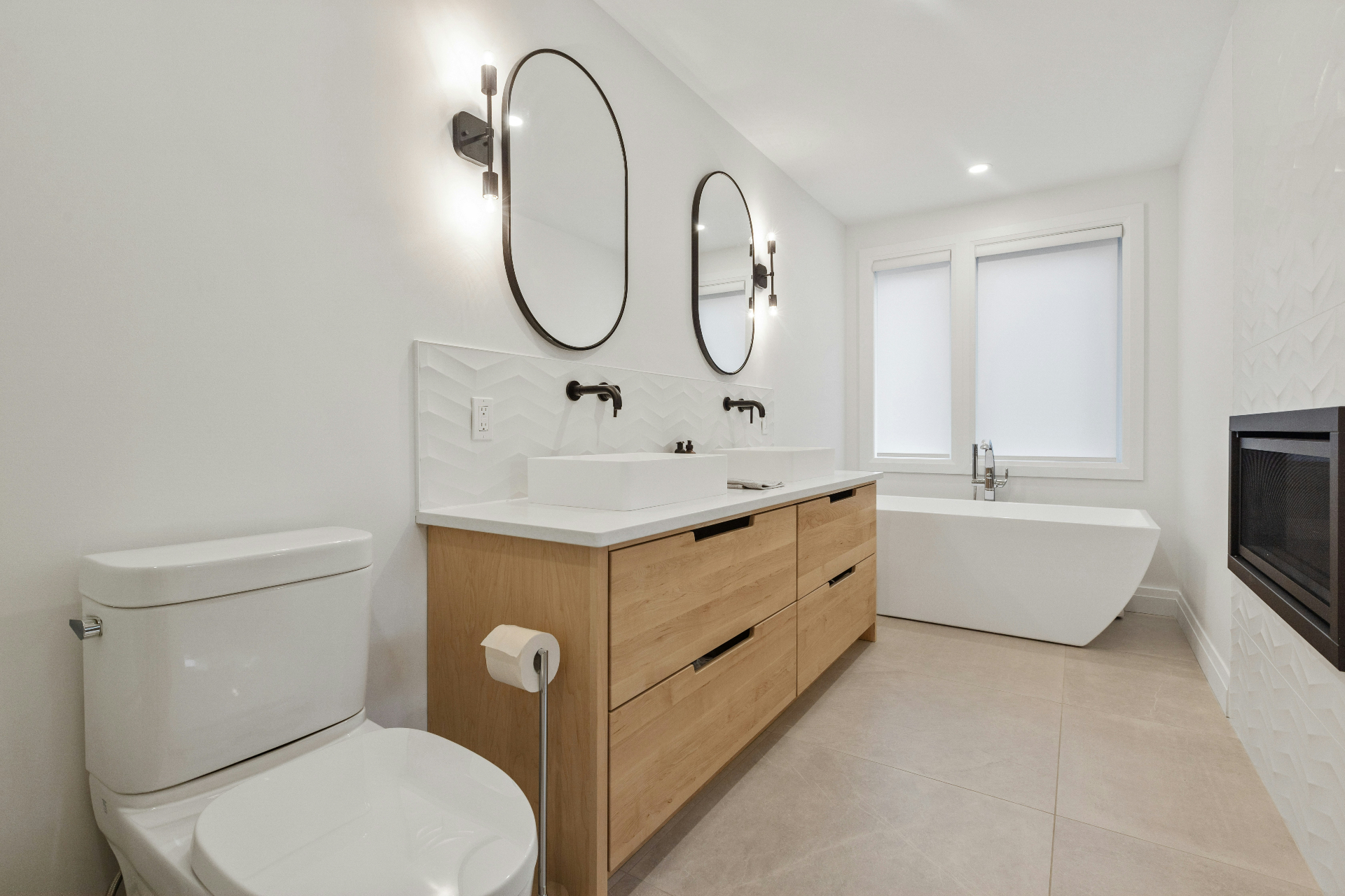 Minimal bathroom remodel with wood vanity and soaking tub completed by EC Builders